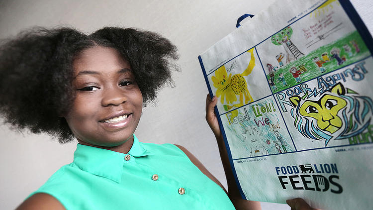 Sierra Harris, who attends Woodside High School, was one of the winners in Food Lion's design a reusable tote contest. Her design is the yellow lion bottom right. She said she heard about the contest from her aunt who manages a Food Lion. (Judith Lowery / Daily Press)
